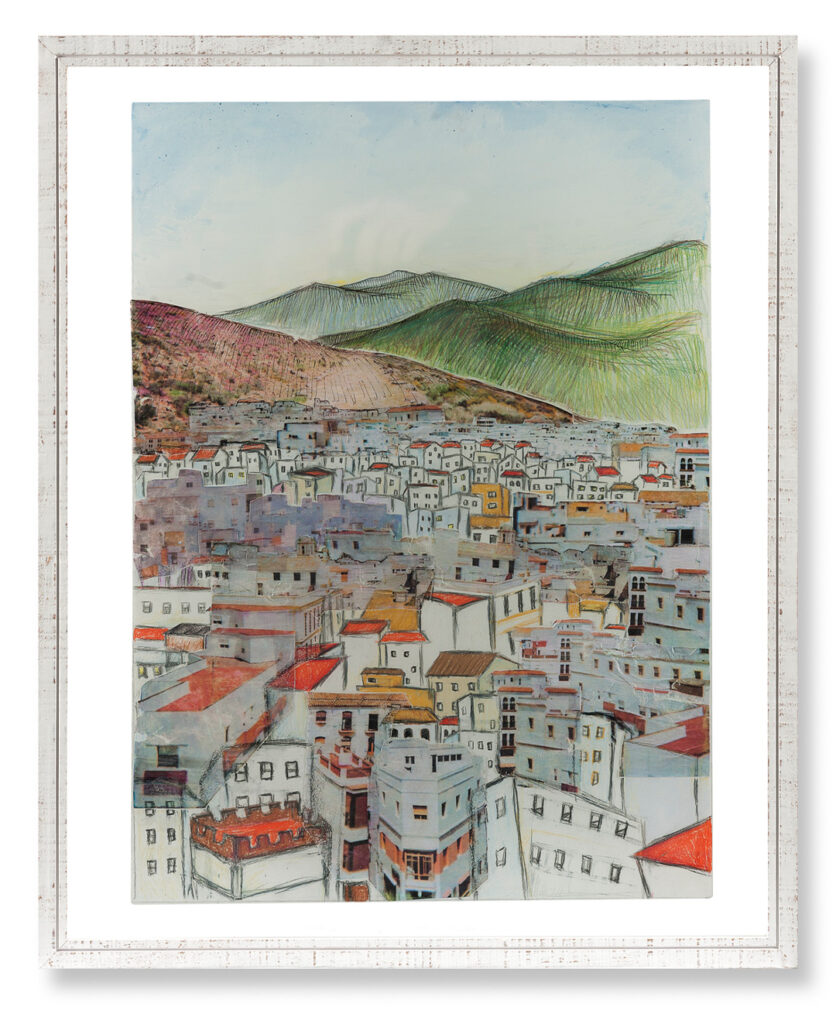 A mixed-media artwork framed in distressed white wood, depicting a dense city of white buildings with colorful roofs clustered at the base of large, textured mountains. The sky above is a pale blue. The style combines architectural drawings with painted or collaged elements.